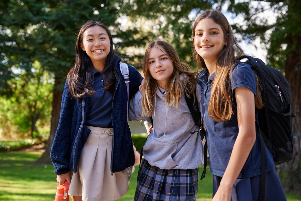 Three Venture Christian Academy middle school girls smiling together outdoors